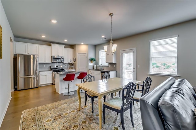 dining space featuring baseboards, wood finished floors, and recessed lighting