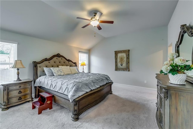 bedroom with a ceiling fan, light colored carpet, vaulted ceiling, and baseboards