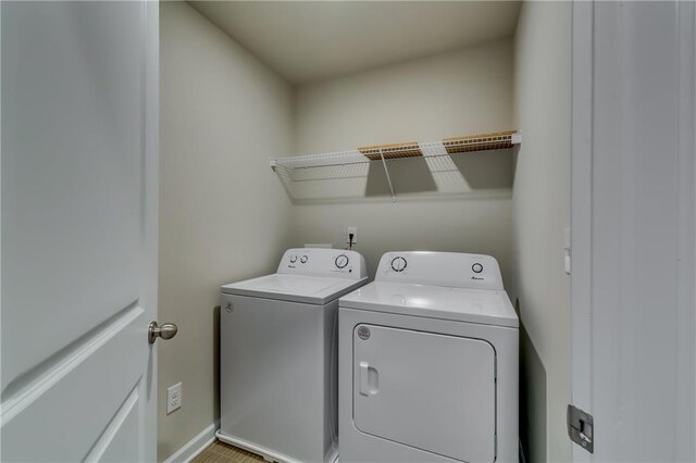 washroom with laundry area, independent washer and dryer, and baseboards