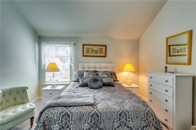 bedroom with lofted ceiling and baseboards