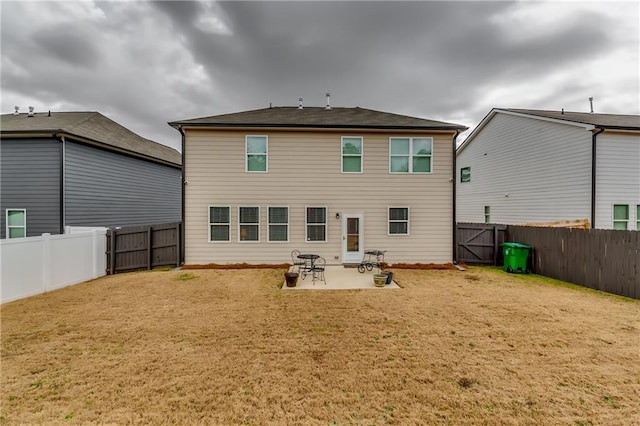 rear view of house with a yard, a fenced backyard, and a patio