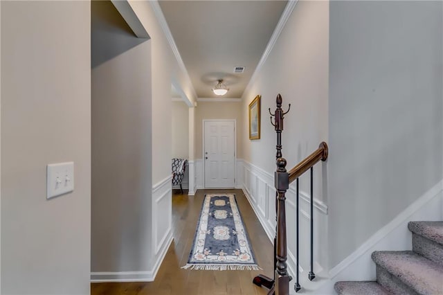 interior space with visible vents, a decorative wall, ornamental molding, wainscoting, and wood finished floors