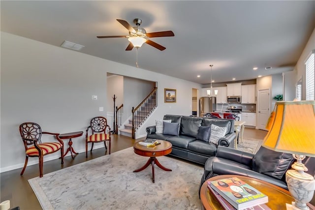 living area featuring recessed lighting, a ceiling fan, baseboards, stairs, and visible vents