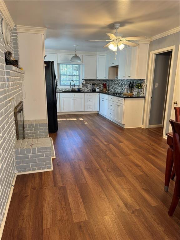 kitchen featuring ceiling fan, sink, black fridge, dark hardwood / wood-style flooring, and white cabinets