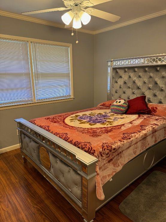 bedroom featuring ceiling fan, dark hardwood / wood-style flooring, and ornamental molding