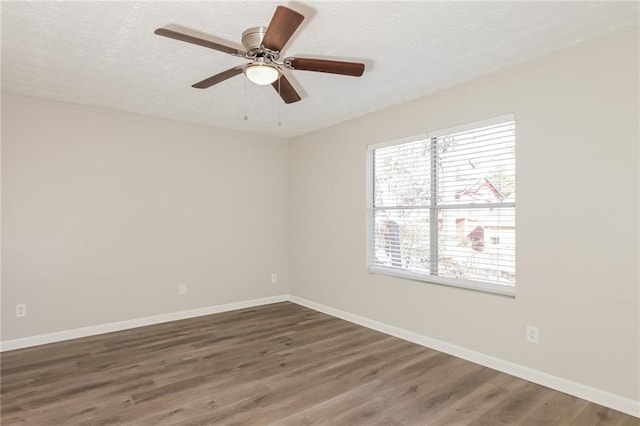 empty room with ceiling fan, a textured ceiling, and dark hardwood / wood-style flooring