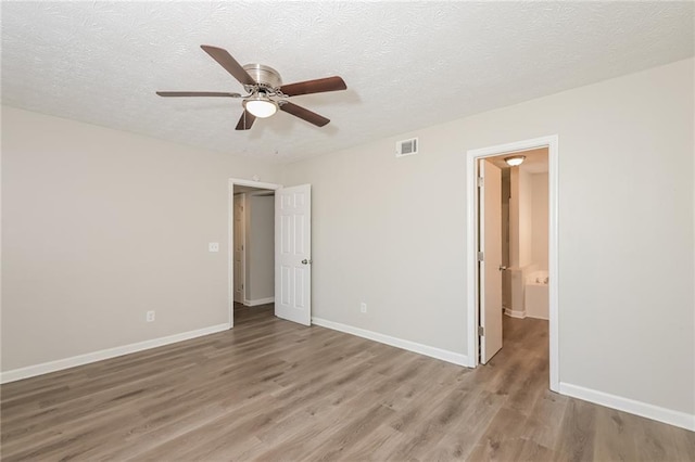 spare room featuring ceiling fan, hardwood / wood-style floors, and a textured ceiling