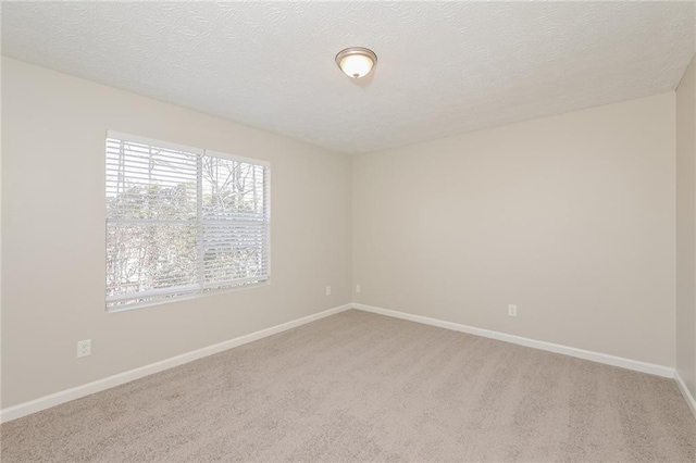 carpeted spare room featuring a textured ceiling