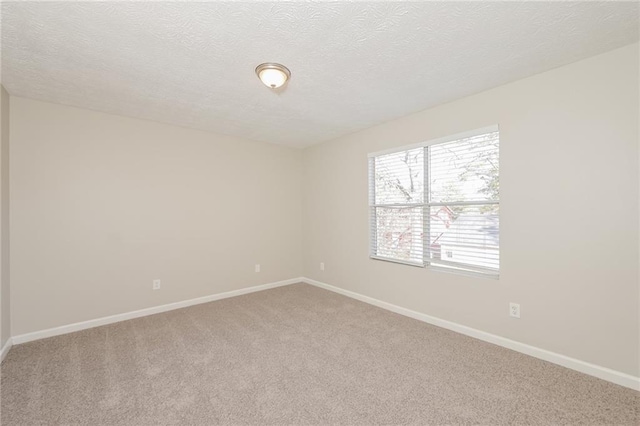 carpeted empty room with a textured ceiling