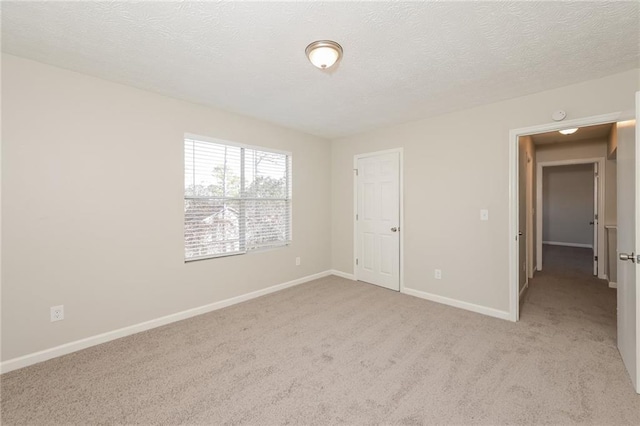 unfurnished bedroom with light colored carpet and a textured ceiling