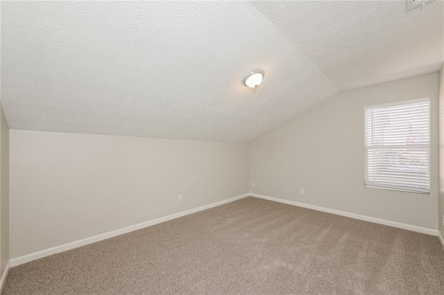 additional living space featuring lofted ceiling, a textured ceiling, and carpet flooring