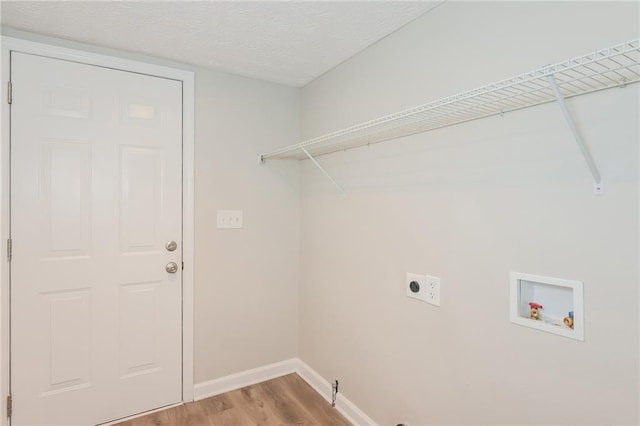 laundry room featuring wood-type flooring, hookup for a washing machine, a textured ceiling, and electric dryer hookup