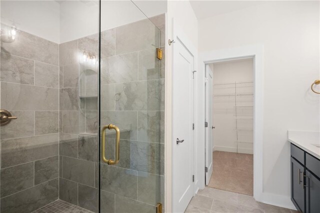 bathroom with tile patterned flooring, vanity, and a shower with door