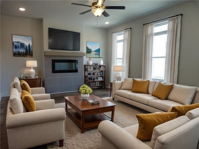 living room with ceiling fan, a fireplace, and light wood-type flooring