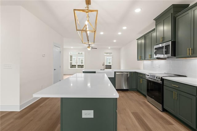 kitchen featuring green cabinets, a kitchen island, and stainless steel appliances