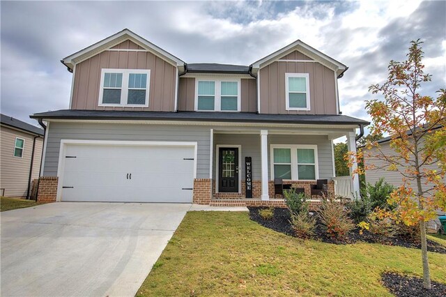 craftsman-style house featuring covered porch, a garage, and a front lawn