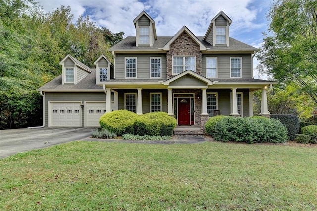 view of front of property with a porch, a front lawn, and a garage