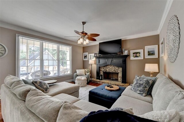 living room with crown molding, a stone fireplace, hardwood / wood-style flooring, and ceiling fan