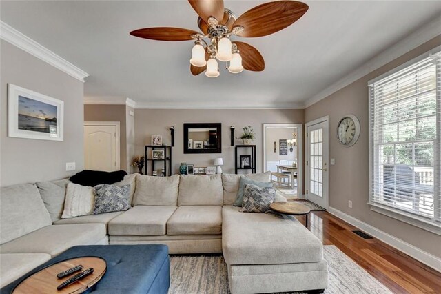 living room featuring crown molding, light wood-type flooring, and ceiling fan