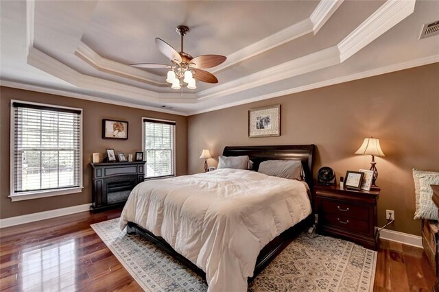 bedroom with ornamental molding, dark wood-type flooring, and ceiling fan