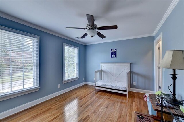 bedroom with light hardwood / wood-style flooring, ornamental molding, and ceiling fan