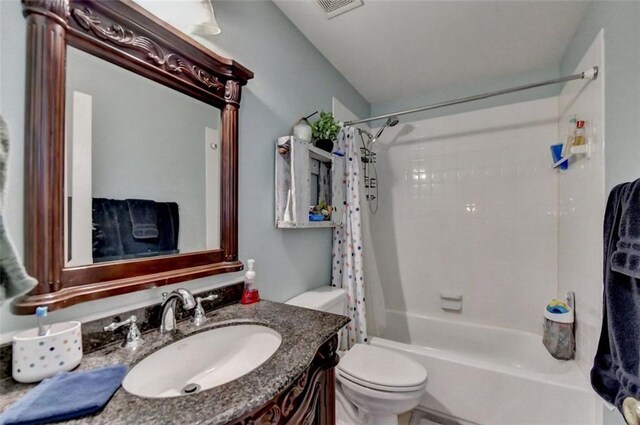 full bathroom with toilet, shower / tub combo with curtain, and vanity