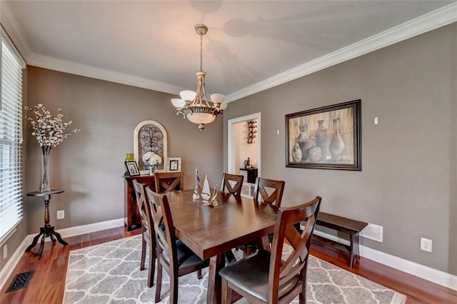 dining room featuring crown molding, a chandelier, and wood-type flooring