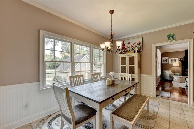 dining room with wood-type flooring, ornamental molding, and a chandelier