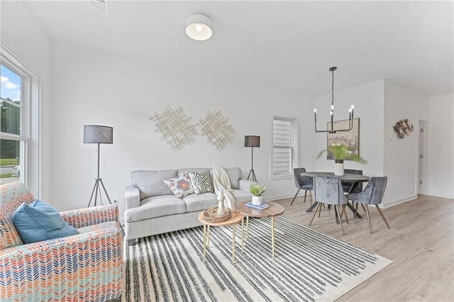 170 Chandler Trce, Covington, GA 30016 - living room with a chandelier, light wood-type flooring, and baseboards