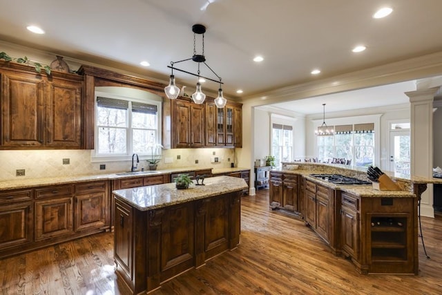 5284 Vernon Springs Trl, Sandy Springs, GA 30327 - kitchen featuring a kitchen island, a sink, ornamental molding, stainless steel gas cooktop, and dark wood-style flooring