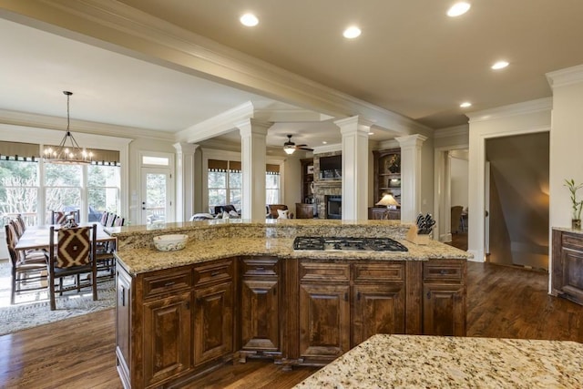 5284 Vernon Springs Trl, Sandy Springs, GA 30327 - kitchen with gas stovetop, ceiling fan, a fireplace, ornate columns, and ornamental molding