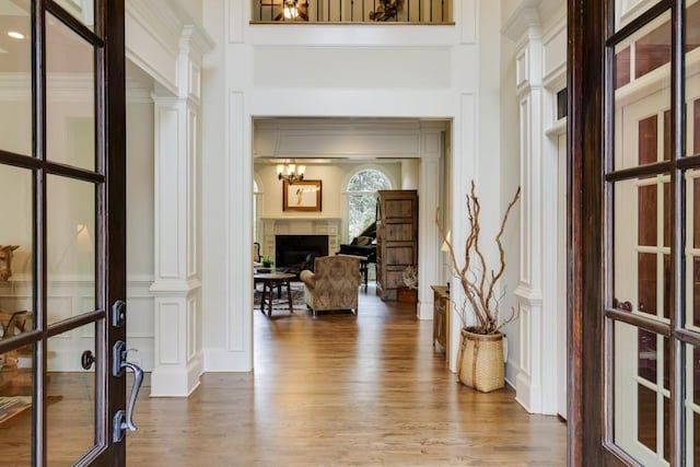 5284 Vernon Springs Trl, Sandy Springs, GA 30327 - foyer featuring wood finished floors, decorative columns, a decorative wall, a towering ceiling, and a fireplace