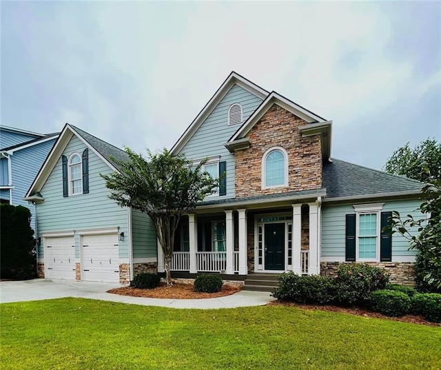 view of front of property featuring driveway, stone siding, a garage, and a front yard