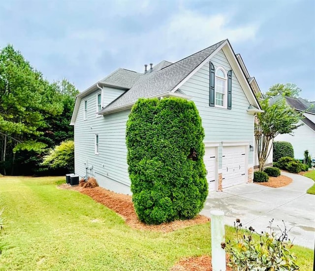 view of side of home featuring a garage and a yard