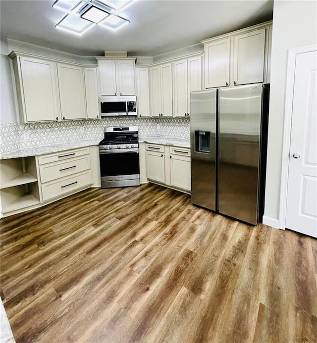 kitchen with appliances with stainless steel finishes, light countertops, light wood finished floors, and open shelves