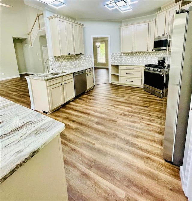 306 Mountain Laurel Walk, Canton, GA 30114 - kitchen featuring appliances with stainless steel finishes, a sink, light wood-style floors, and decorative backsplash