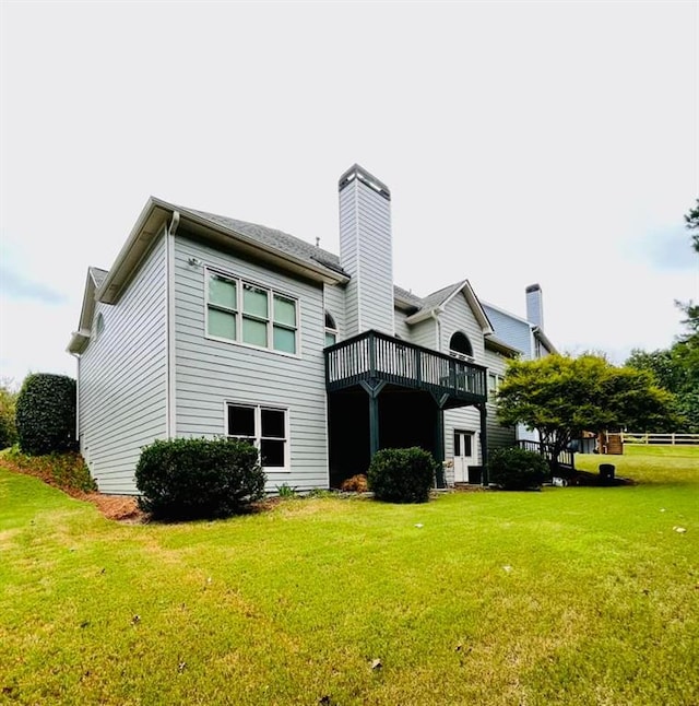 rear view of house with a yard and a deck