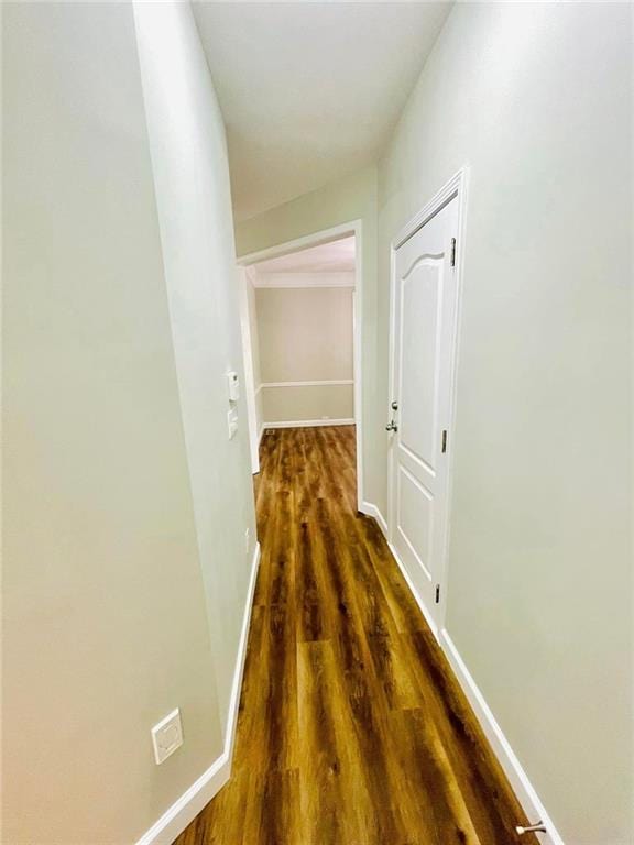 hallway with dark wood-type flooring and baseboards