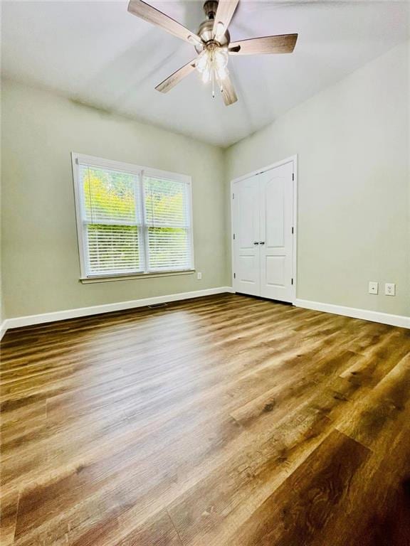 spare room with a ceiling fan, baseboards, and wood finished floors