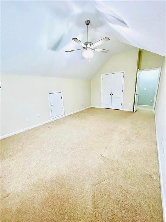 additional living space with light carpet, ceiling fan, lofted ceiling, and baseboards