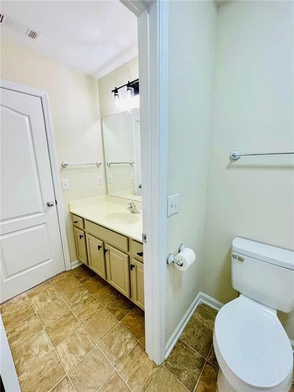 bathroom featuring visible vents, vanity, toilet, and baseboards