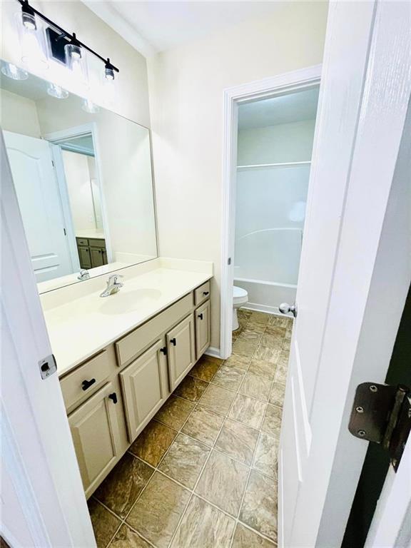 full bath featuring vanity and toilet