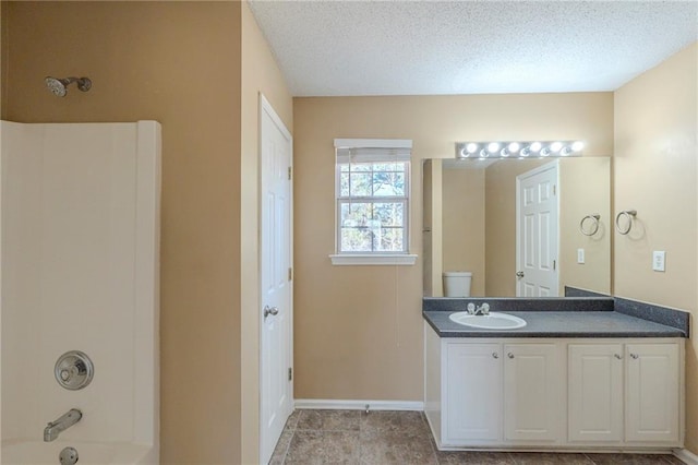 full bathroom with shower / washtub combination, toilet, vanity, and a textured ceiling