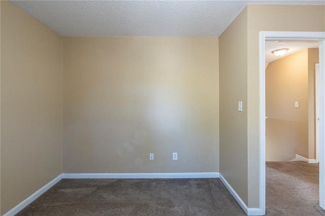 spare room featuring dark carpet and a textured ceiling