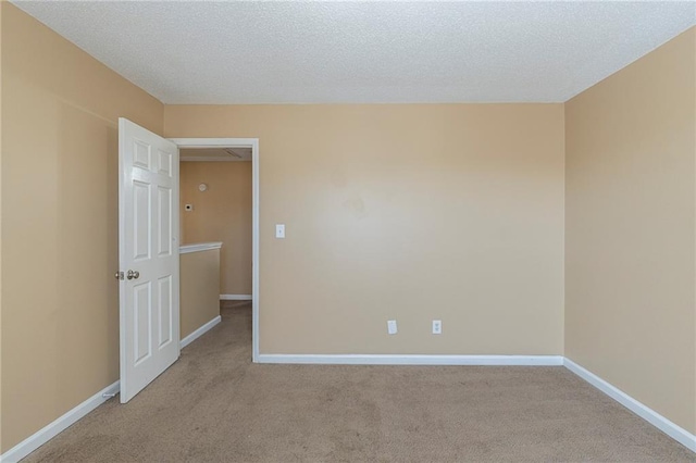 unfurnished room with light carpet and a textured ceiling