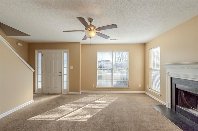 carpeted foyer with ceiling fan and a textured ceiling