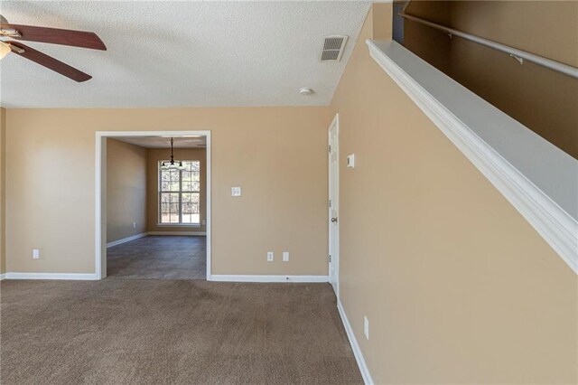 unfurnished living room with a wealth of natural light, light colored carpet, and a textured ceiling