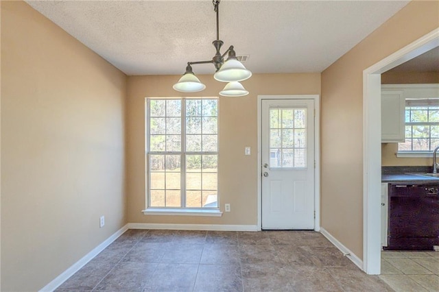 entryway with sink, an inviting chandelier, and a textured ceiling