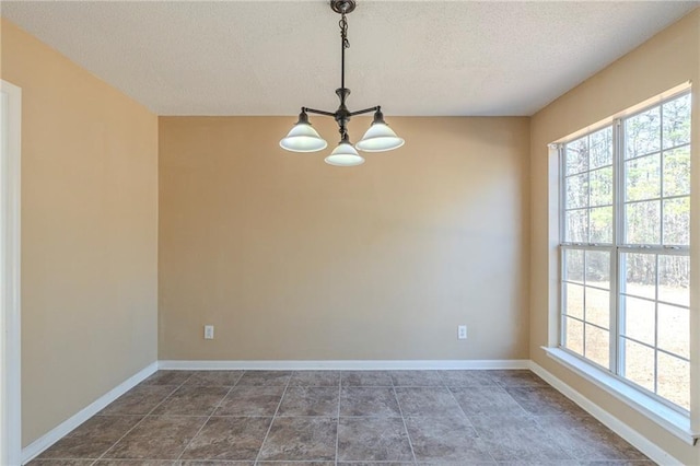 unfurnished room with a textured ceiling and a chandelier