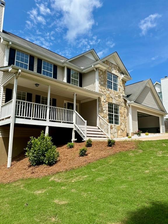 80 Valley Brook Dr, Dawsonville, GA 30534 - view of front of property featuring a porch, stone siding, a front lawn, a garage, and a chimney